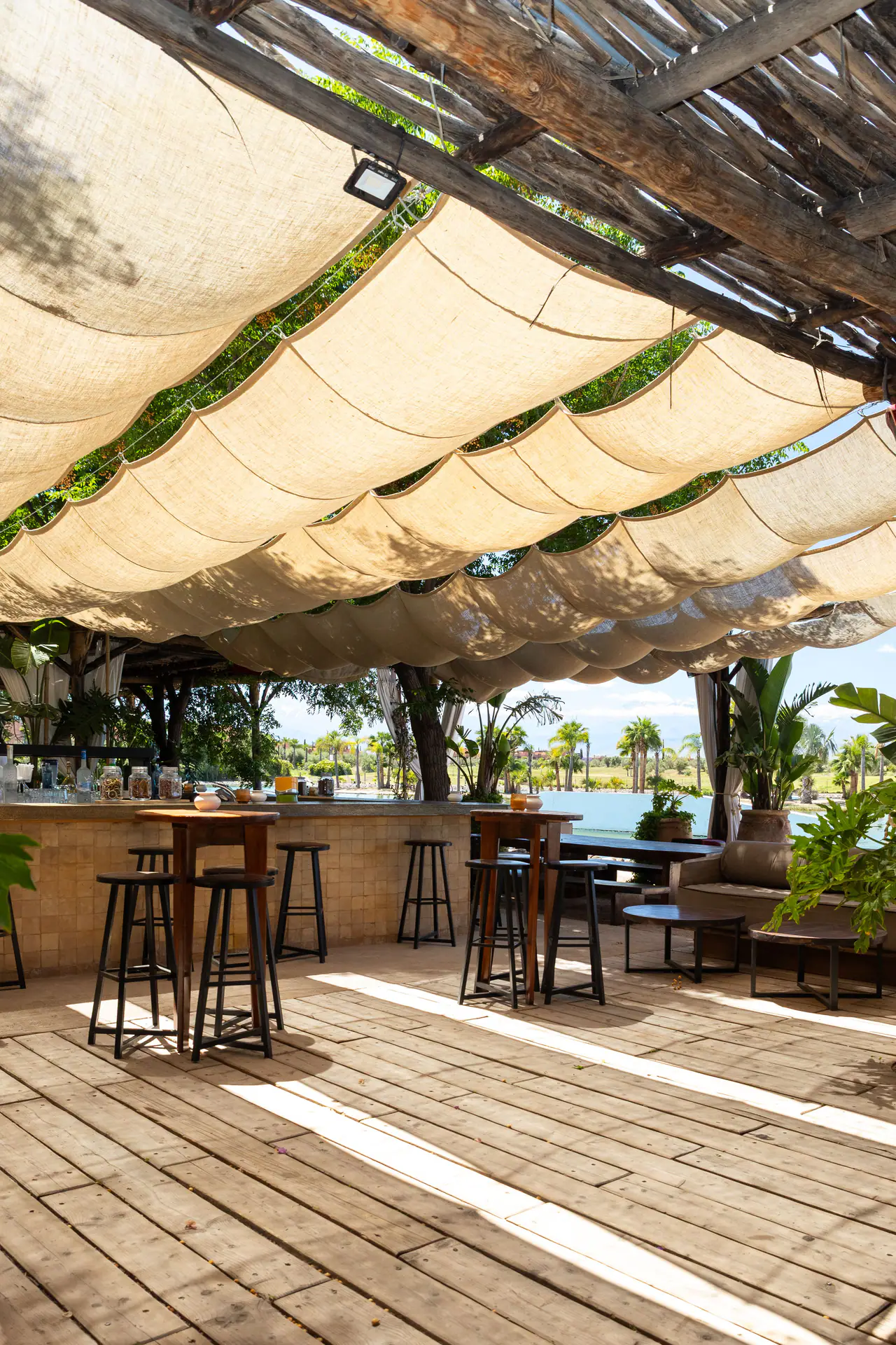 Le bar sous les voiles d’ombrage, avec vue sur le lac