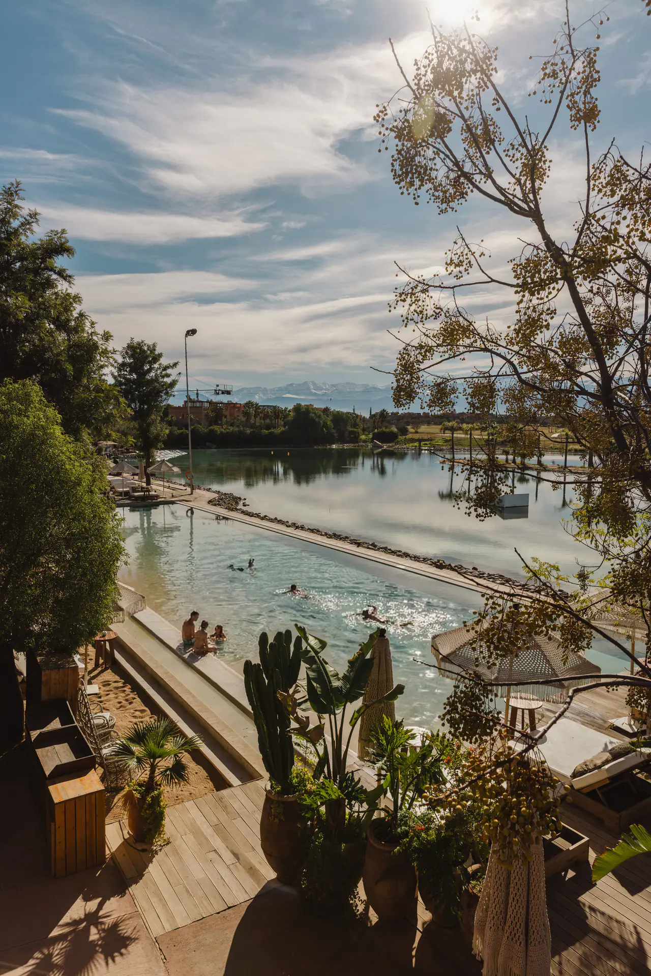 Baigneurs dans la piscine, avec le lac et l’Atlas au loin