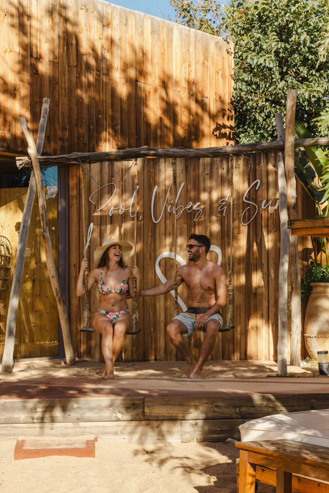 Balançoires devant le panneau « Good Vibes & Sun »